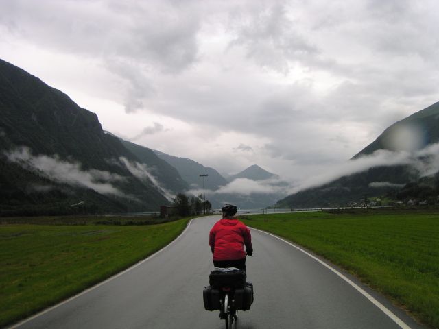 Damae cycling ahead of me against the backdrop of Fjærland.